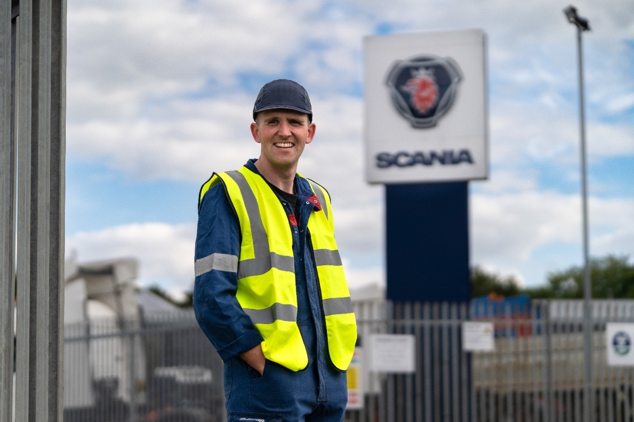Field Technician Craig Moore standing outside in front of Scania sign