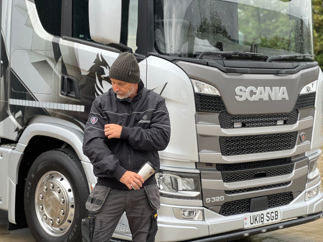 Scania employee wearing merchandise infront of G320 truck