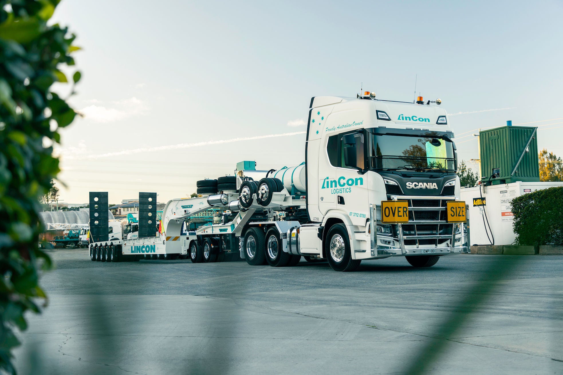White LinCon semi-truck with an oversize heavy-haul trailer.