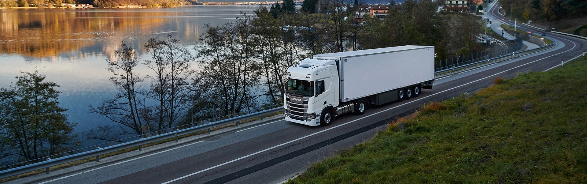 Camion Scania Série R blanc sillonnant une petite route, au meilleur de son rendement énergétique