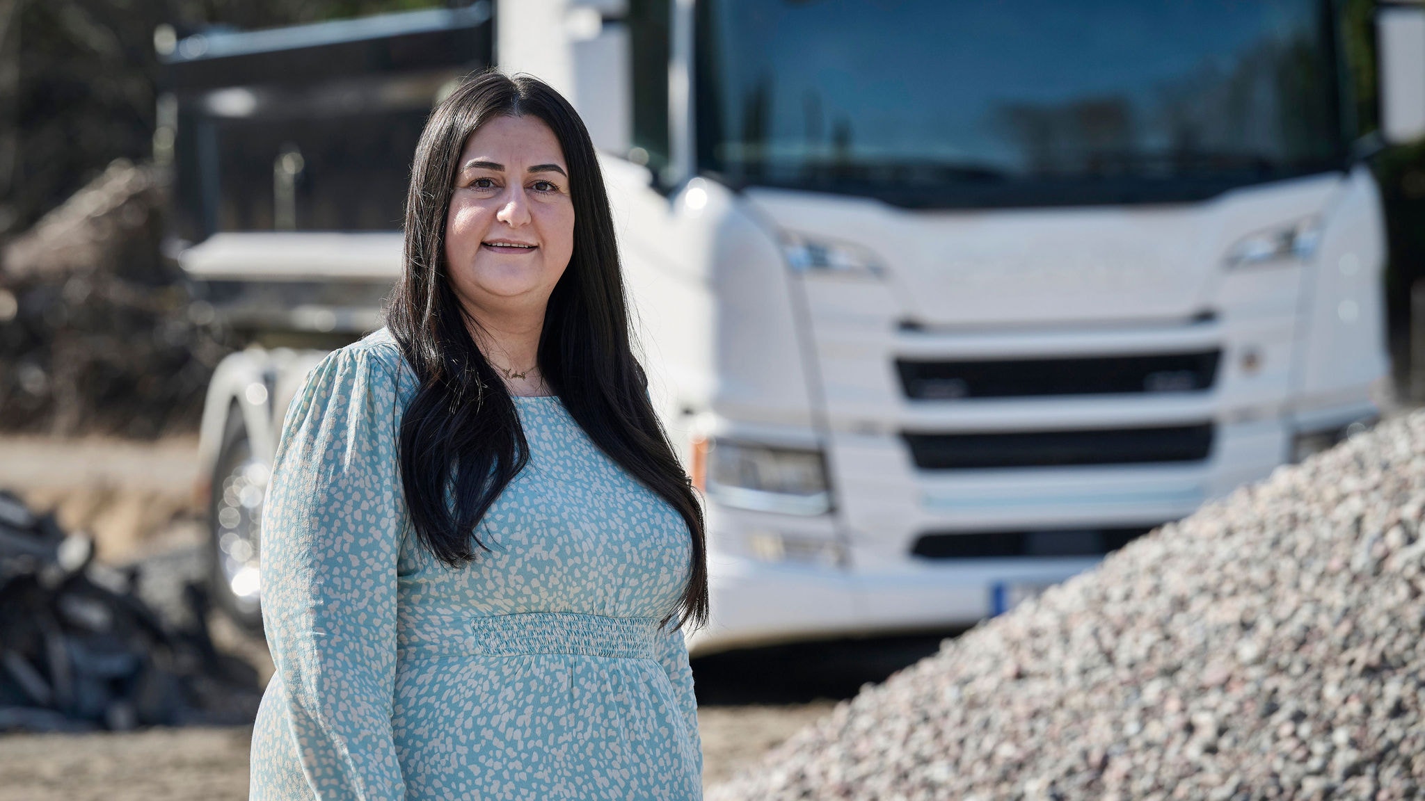 Kushink Bazaz, e-Truck Product Manager at Scania, standing infront of a truck in a gravel pit.