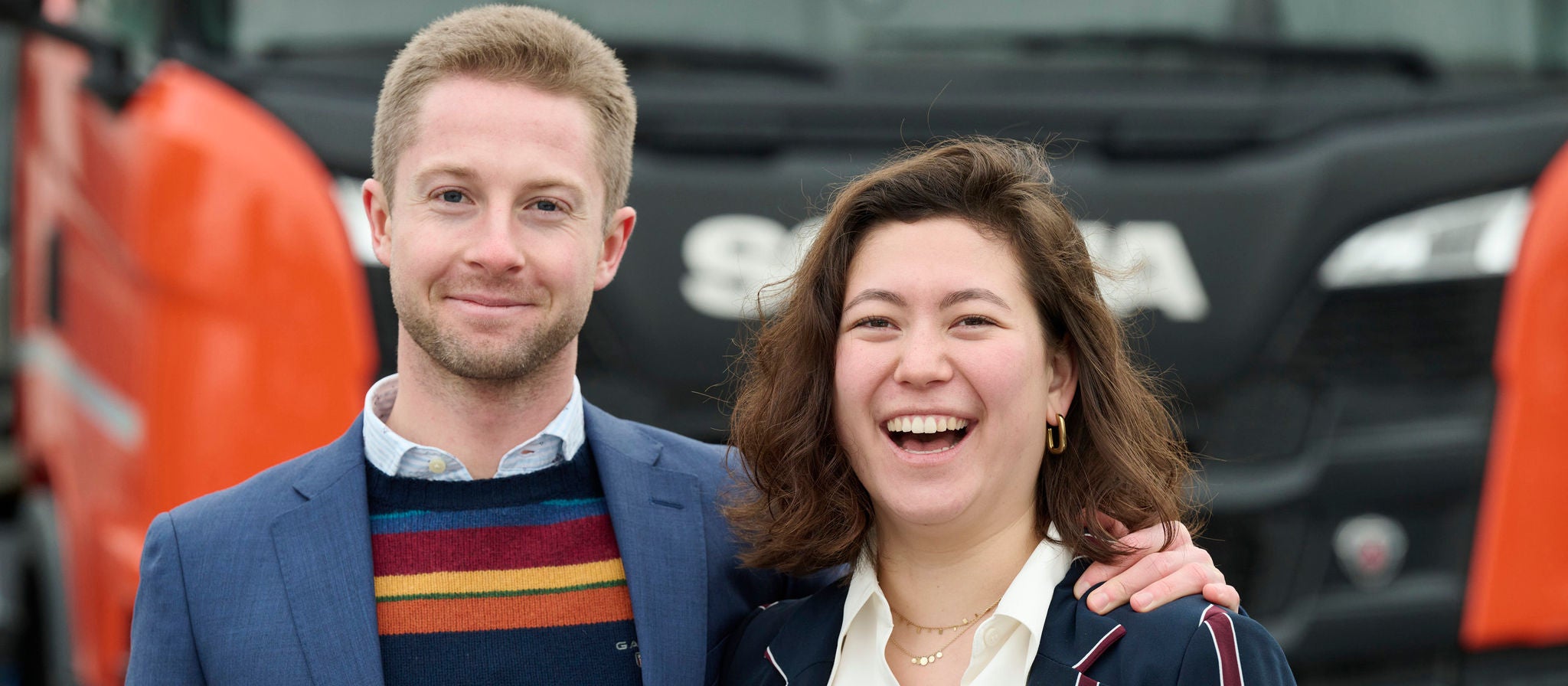 Scania employees, man and woman, in front of a Scania truck