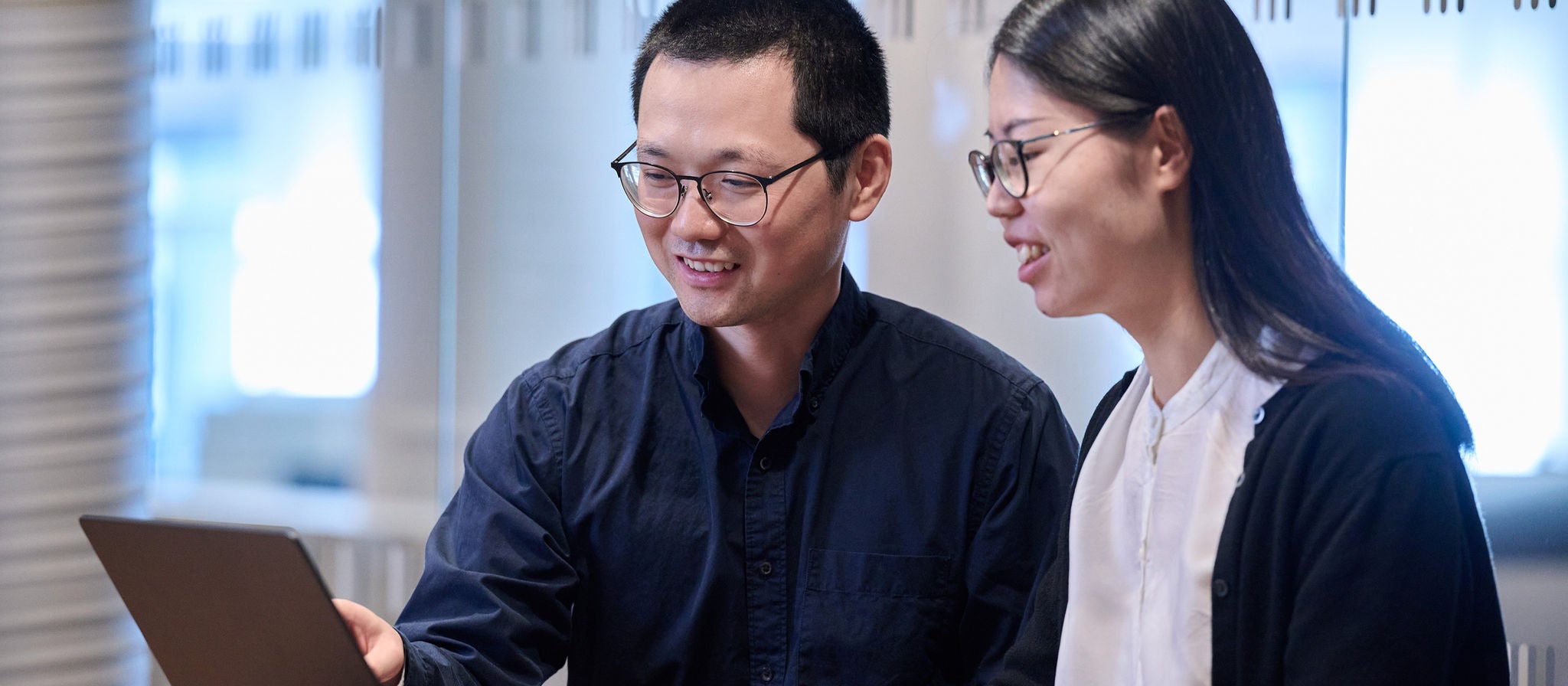 Ziwei Huang, Development Engineer and Yang Xiao, CAE Engineer at Scania, looking at a laptop.