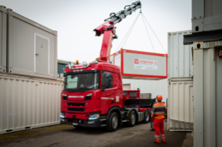 Dank leistungsfähigem Palfinger PK 65002 Frontkran lassen sich sogenannte Wohneinheiten des Kunden Würzburger AG schnell und sicher auf- oder im Depot wieder abladen.