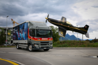 Der BEV Scania vor dem Wahrzeichen von Buochs, dem Kreisel mit einem Pilatus Flieger.