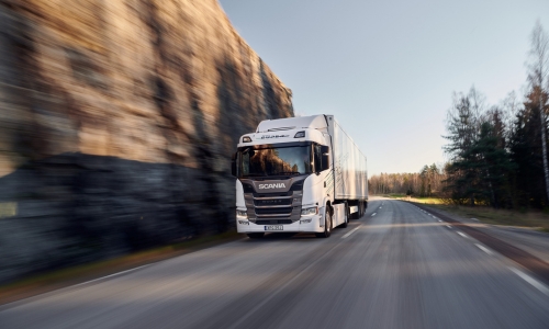 Weißer Scania Super fährt auf Straße