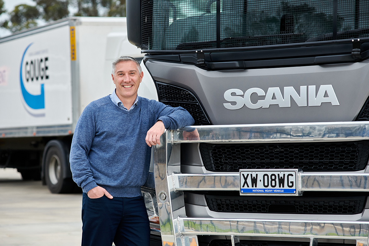 Gouge Linen CEO John Calleja standing beside a Scania truck