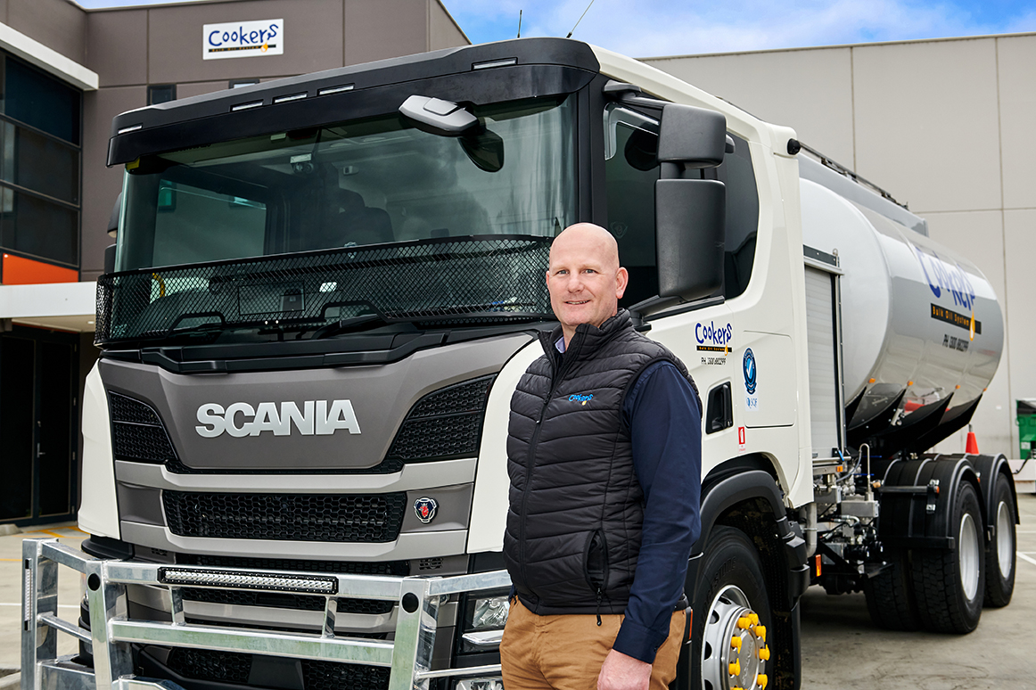 Man standing beside Scania Cookers tanker truck