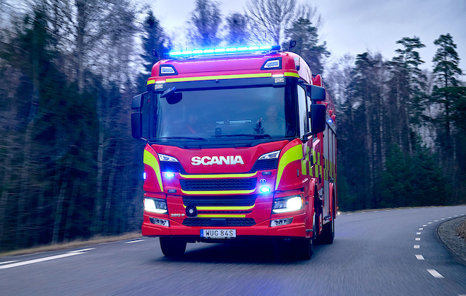 Scania CrewCab 390 P fire truck driving on a forest road