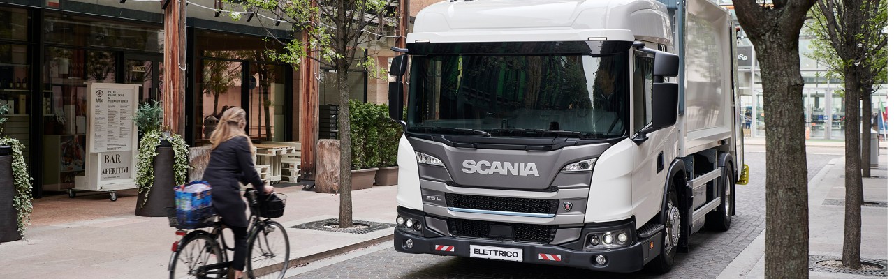L серия на Scania с кабина с нисък вход се движи по малка улица 