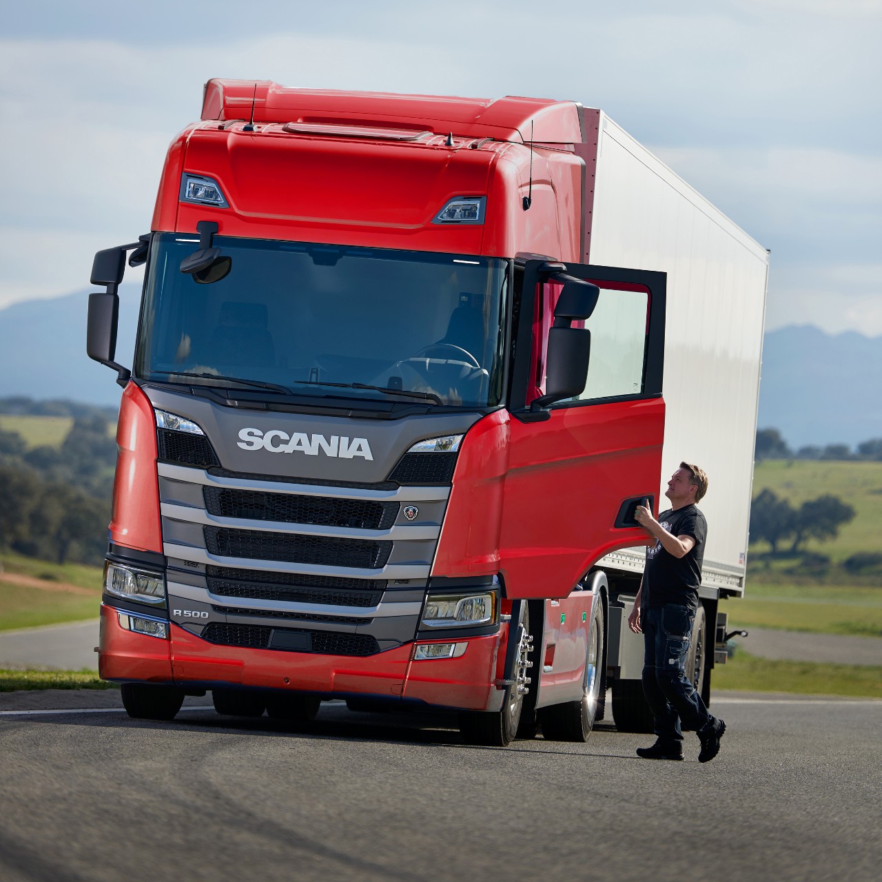 Mann steigt in roten Scania