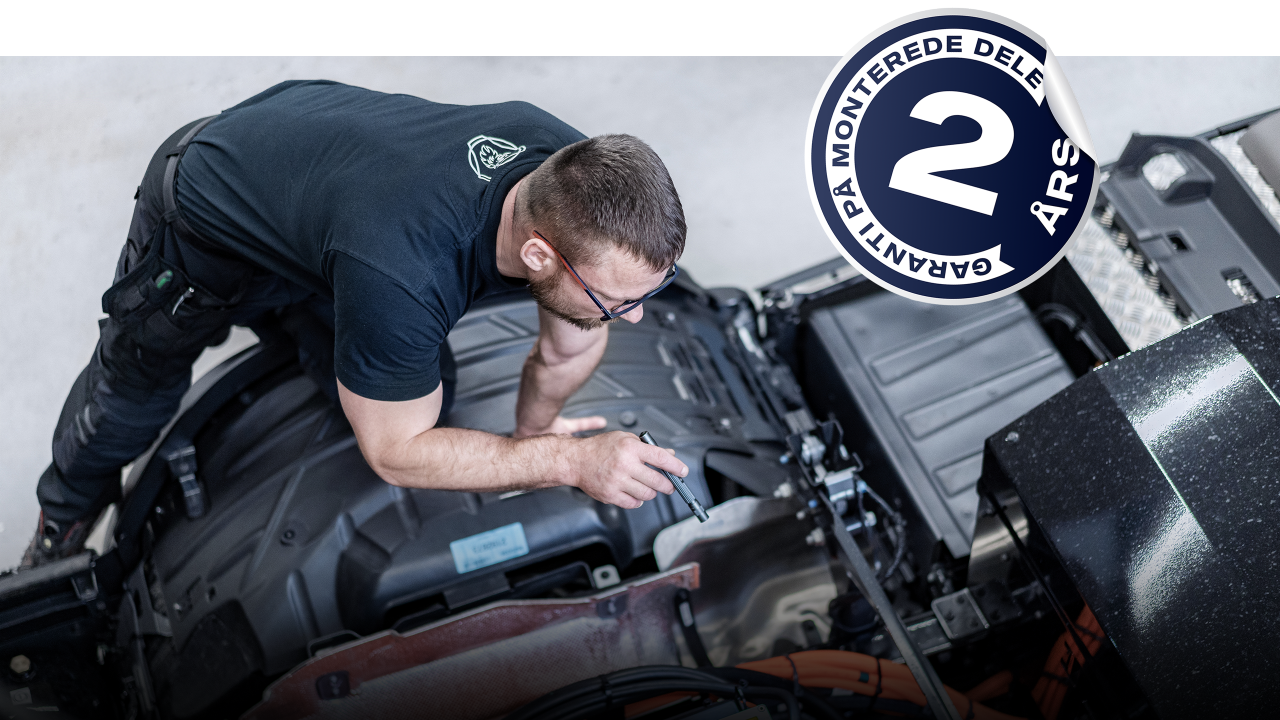 Scania-tekniker, der kigger på lastbil i værksted