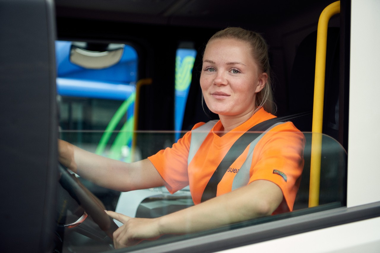 Kvindelig lastbilchauffør sidder i Scania-lastbil