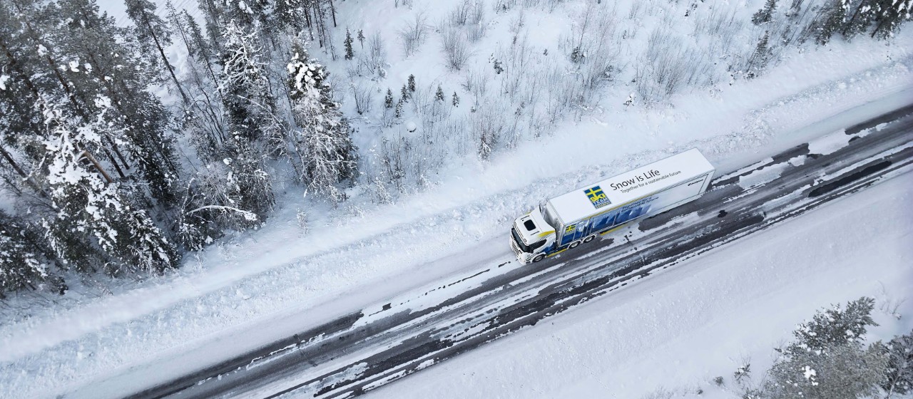 Scania 500 R 6x2 Highline for Swedish cross-country ski team, drives on a snowy road surrounded by a forest