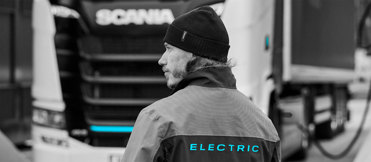 Man in fornt of a Scania BEV