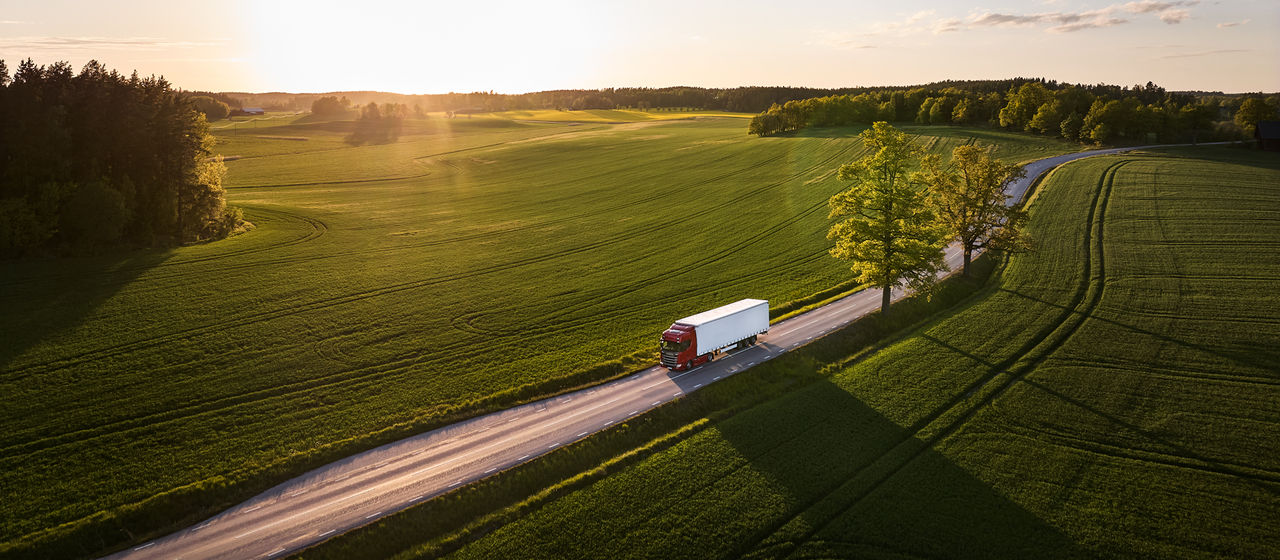 Truck on a road with green fields sunshine