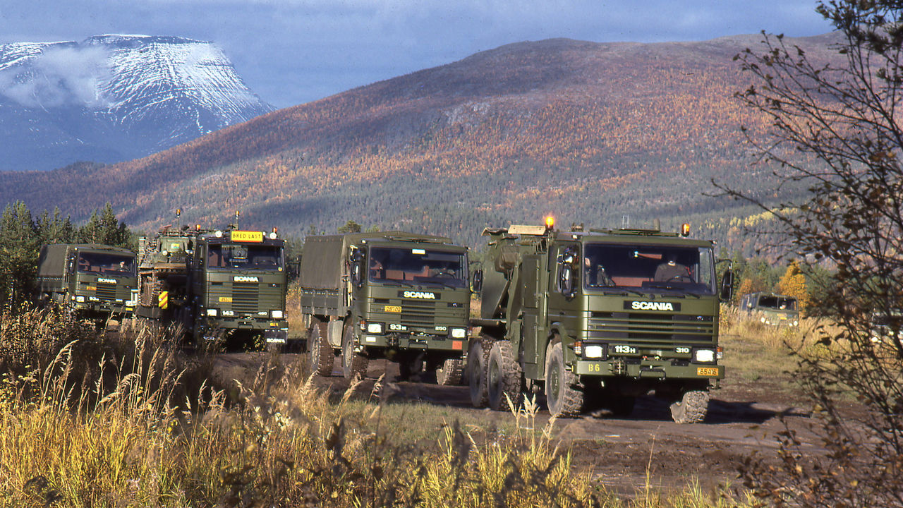 Scania 3-series military trucks driving among mountains