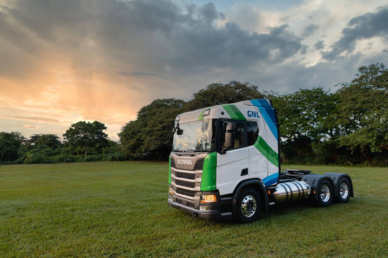 Un Scania serie R blanco pasando por una carretera pequeña con el mejor ahorro de combustible