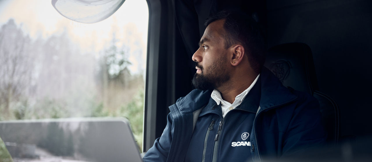Vivek Venkatesh Shenoy sitting inside a Scania truck, looking out through the window during his research work.