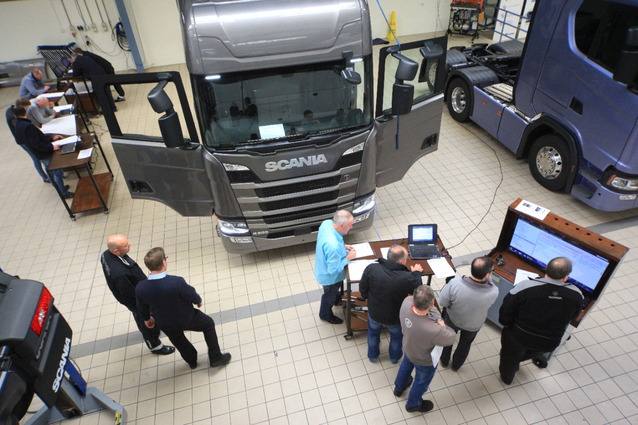 Technicians in training room with Scania trucks