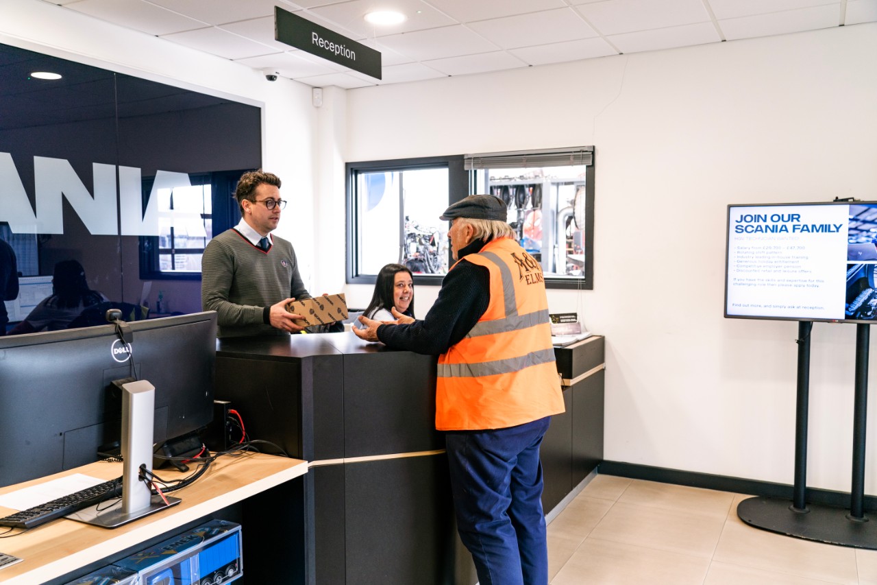 Scania colleauges standing at desk in branch