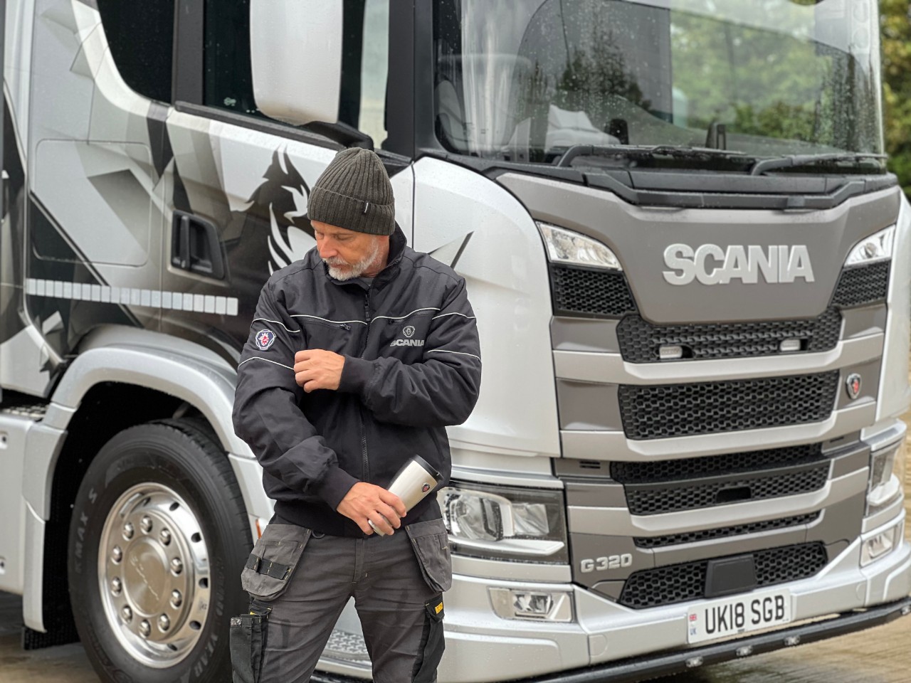 Scania employee wearing merchandise infront of G320 truck