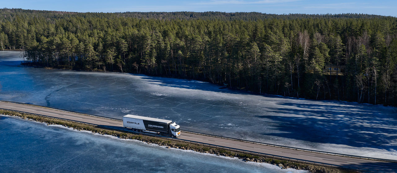 Scania truck driving by icy water